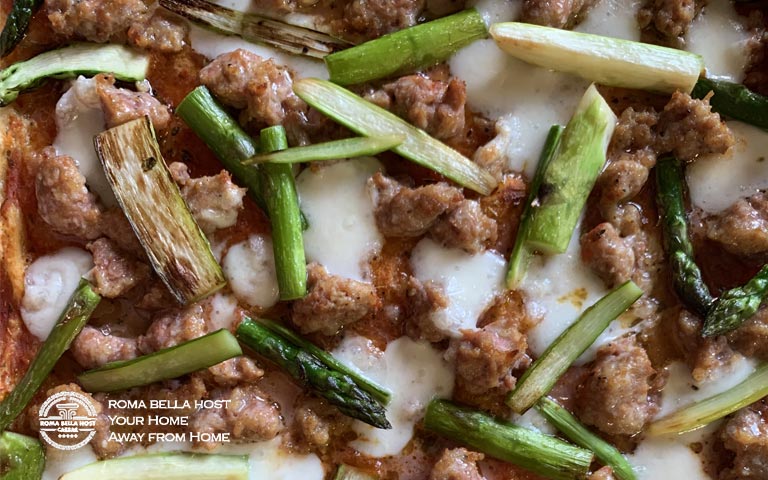 Pizza nướng khay với xúc xích và măng tây trồng trong vườn Roma Bella Host